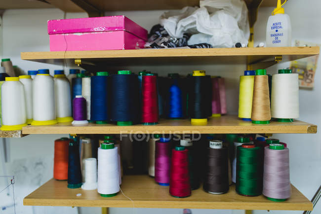 Shelves with various spools at workshop — Stock Photo
