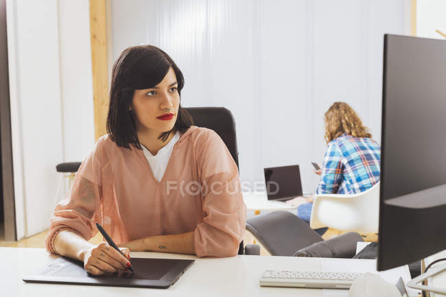 Дівчина використовує графічний планшет в офісі — стокове фото