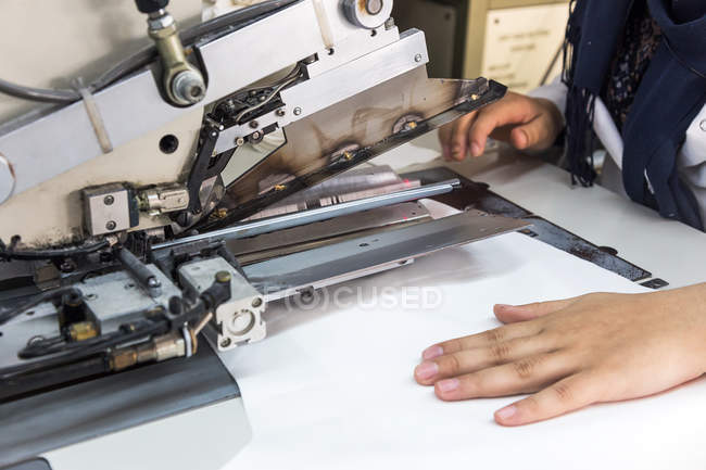 Crop worker using machinery at clothes fabric — Stock Photo