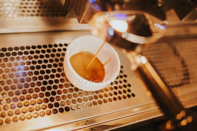 Vista de alto ângulo da máquina derramando café na xícara — Fotografia de Stock