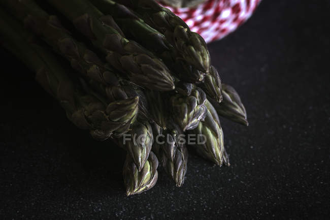 Espargos verdes frescos em preto — Fotografia de Stock