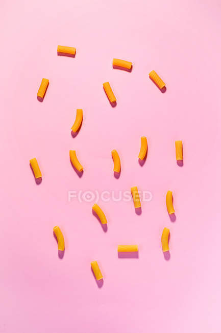 Желтые макароны на розовом — стоковое фото