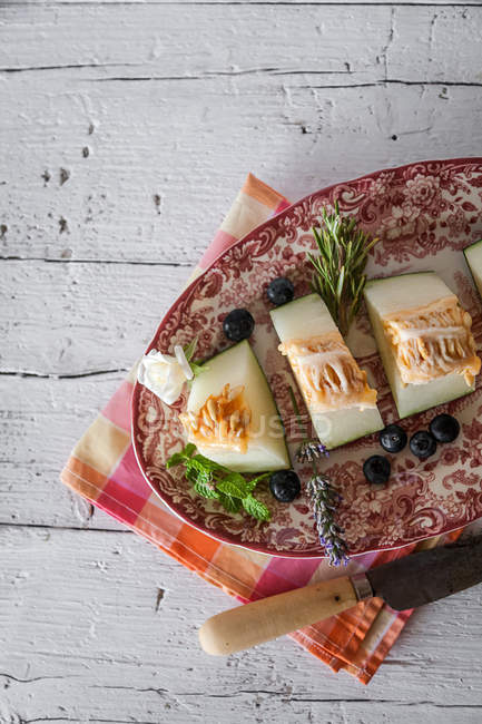 Prato ornamentado com delicioso melão na mesa rural — Fotografia de Stock