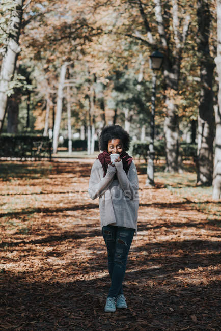 Retrato de una chica tomando café en el parque de otoño en un día soleado - foto de stock