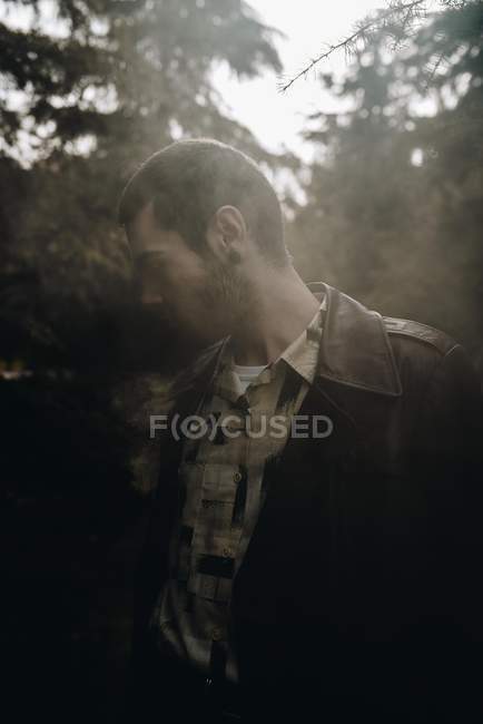 Чоловік стоїть у лісі на тлі диму — стокове фото