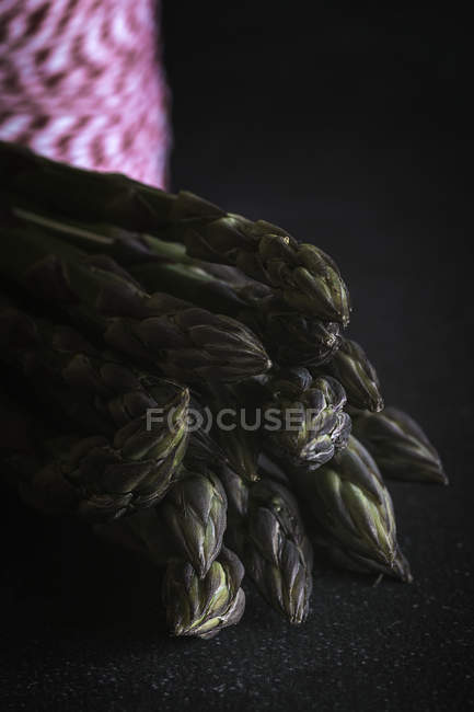 Asperges vertes fraîches sur noir — Photo de stock