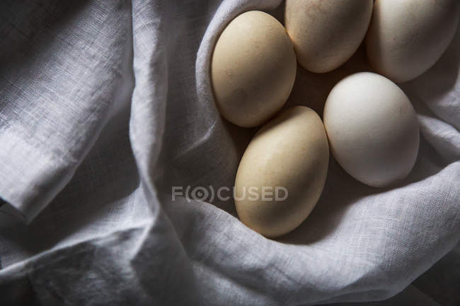 De arriba los huevos blancos sobre la toalla rural - foto de stock