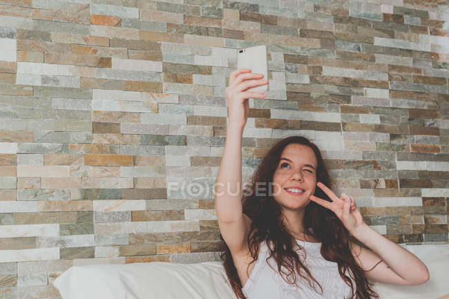 Mulher de gengibre com cabelo ondulado fazendo selfie — Fotografia de Stock