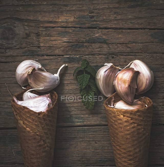 Disposizione delle colture di aglio e coni di cialde sulla tavola rurale — Foto stock