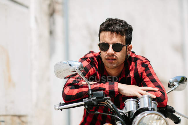 Homme en lunettes de soleil assis sur le vélo — Photo de stock