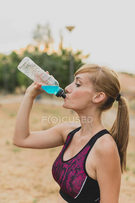 Спортсменка пьет воду после бега — стоковое фото