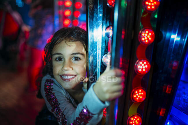 A little child holding and smiling while riding a merry-go-round. Horizontal outside portrait — Stock Photo