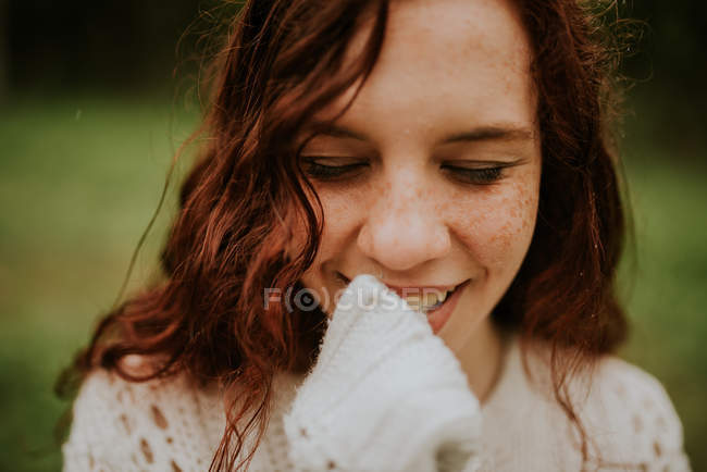 Sinnliches Ingwermädchen, das lächelt und nach unten schaut — Stockfoto