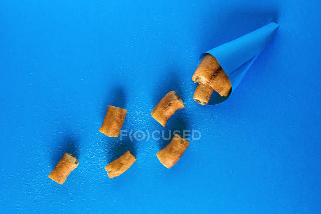 Churros em cone de papel em azul — Fotografia de Stock