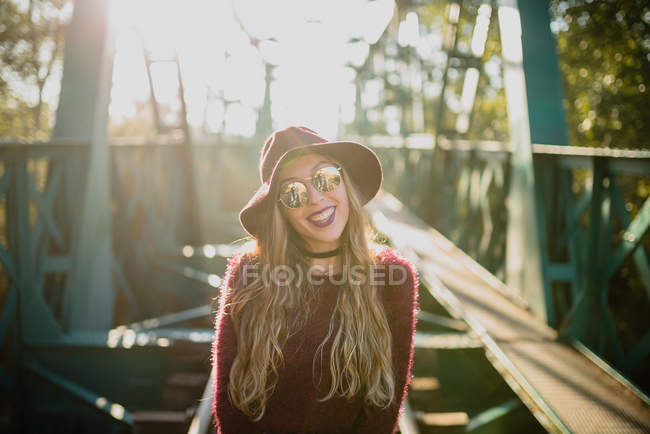 Girl in sunglasses on bridge. — Stock Photo