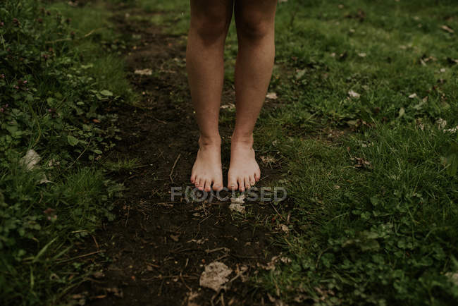 Обнаженные женские ноги стоят на земле — стоковое фото