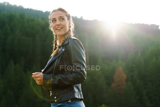Веселая женщина идет по лугу и смотрит в сторону — стоковое фото