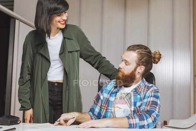 Чоловік і жінка спілкуються в офісі — стокове фото