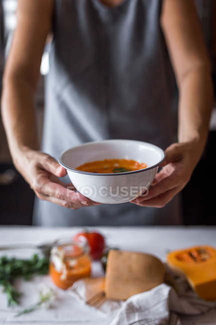 Femme avec bol de soupe à la citrouille — Photo de stock