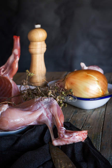 Carcass of raw rabbit with ingredients on wooden table — Stock Photo