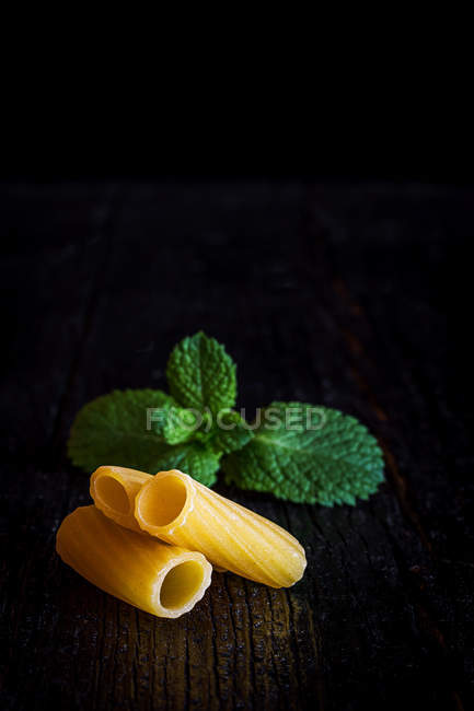 Uncooked pasta with mint leaves — Stock Photo