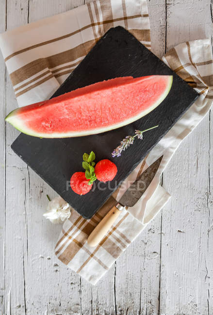 Cuña de sandía fresca y fresas en pizarra - foto de stock