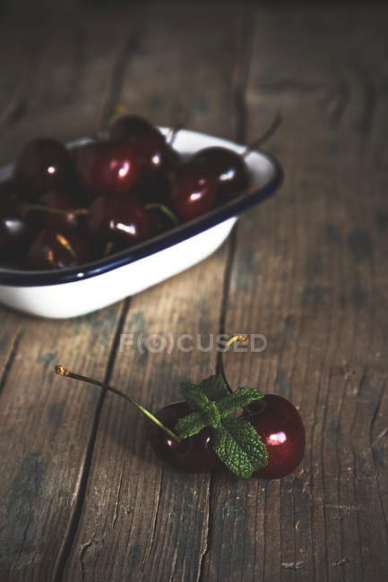 Still life of cherries on rural wooden table — Stock Photo