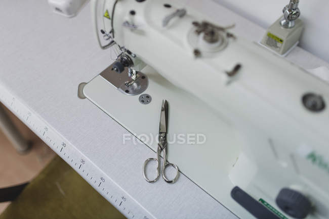 Vista de ángulo alto de las tijeras en la máquina de coser - foto de stock