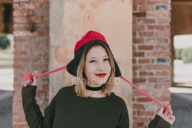 Девушка в вязаной шляпе смотрит в камеру — стоковое фото