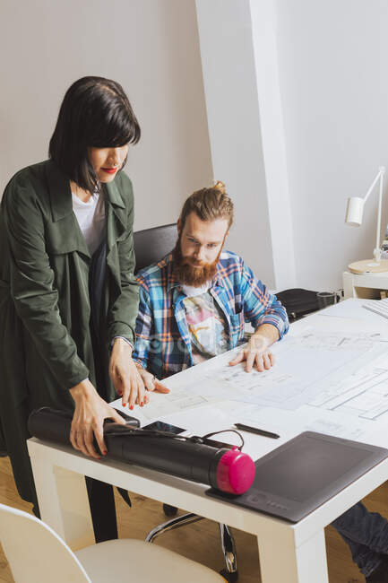 Portrait of architect team discussing blueprint at workplace in office — Stock Photo