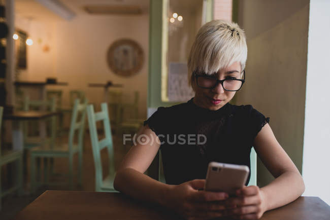 Дівчина використовує смартфон у кафе — стокове фото