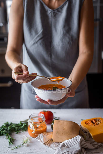 Femme avec bol de soupe à la citrouille — Photo de stock