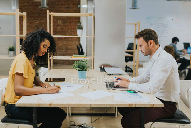 Femme et homme assis et travaillant dans un bureau ouvert. Plan intérieur horizontal — Photo de stock