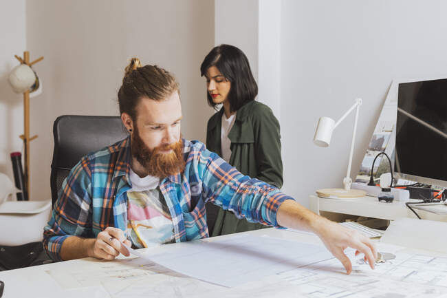Portrait of workers sitting and working with blueprints. — Stock Photo