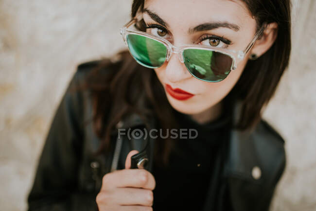 Mulher cortada olhando para cima segurando colarinho de jaqueta no fundo borrado — Fotografia de Stock