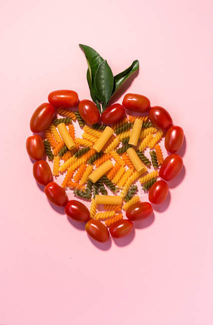 Corazón hecho de tomates y pasta - foto de stock