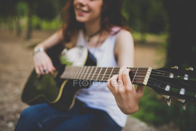 Mid section view of girl playing guitar at countryside scene — Stock Photo