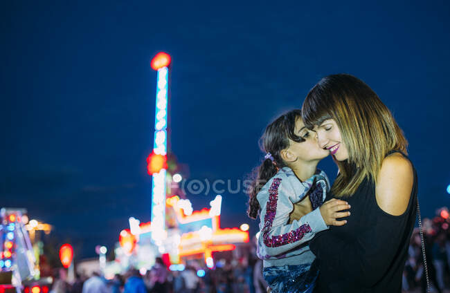 Uma menina dá um beijo à mãe num parque. Horizontal tiro exterior — Fotografia de Stock