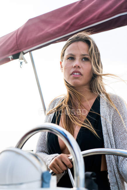 Ritratto di ragazza bionda in piedi al timone dello yacht e guardando da parte — Foto stock