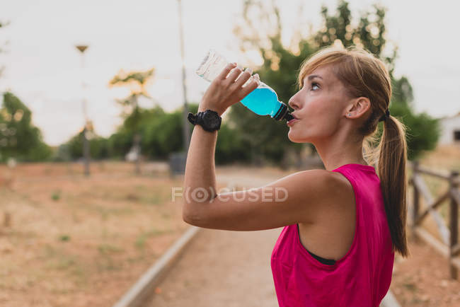 Mujer bebiendo después de correr - foto de stock