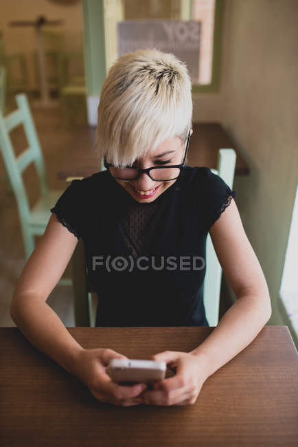 Девушка с помощью смартфона в кафе — стоковое фото