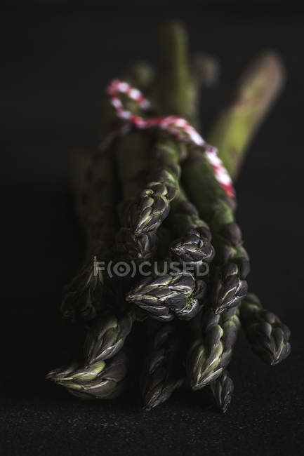 Asparagi verdi freschi su nero — Foto stock