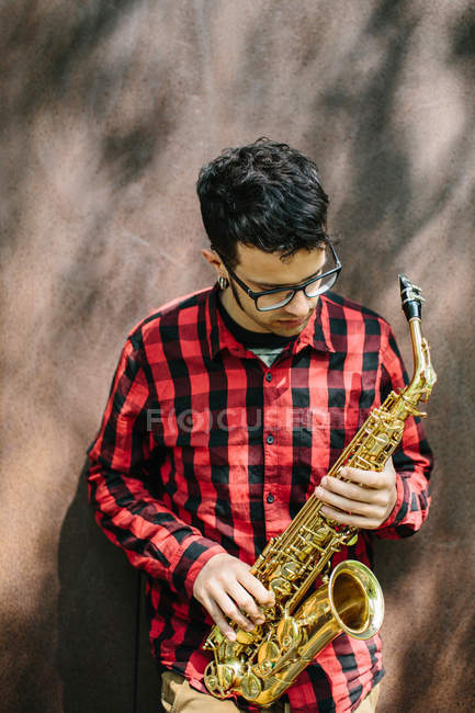 Музыкант держит саксофон — стоковое фото