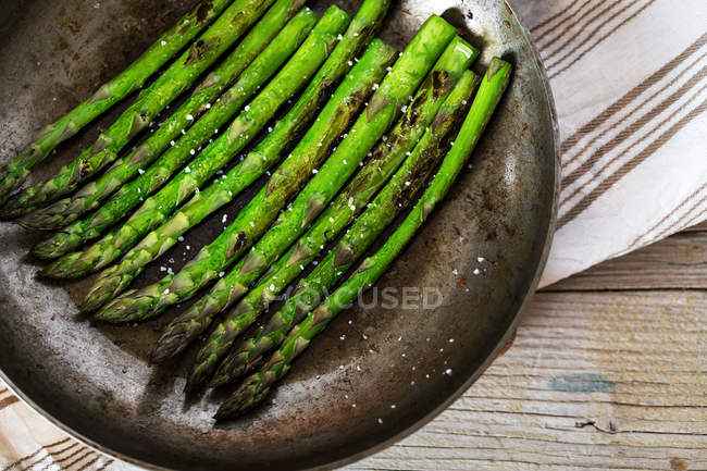 Row of fried asparagus stems on rural table — Stock Photo