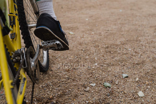 Crop image foot in sneaker on bicycle pedal — Stock Photo