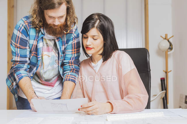 Retrato del hombre y la mujer discutiendo papeles en la oficina - foto de stock