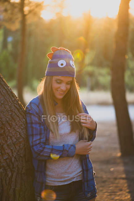 Retrato de menina com chapéu de lã engraçado posando na floresta e olhando para baixo — Fotografia de Stock