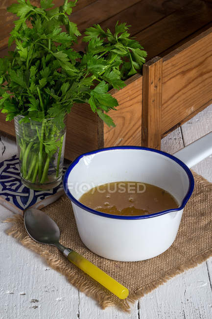 Tigela com sopa e vidro com salsa — Fotografia de Stock