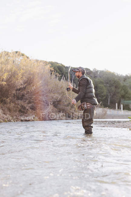 Vista lateral do homem se preparando para jogar gancho para a pesca . — Fotografia de Stock