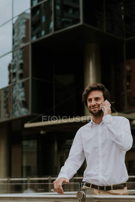 Retrato de homem de negócios sorridente falando no smartphone no centro da cidade cena urbana — Fotografia de Stock